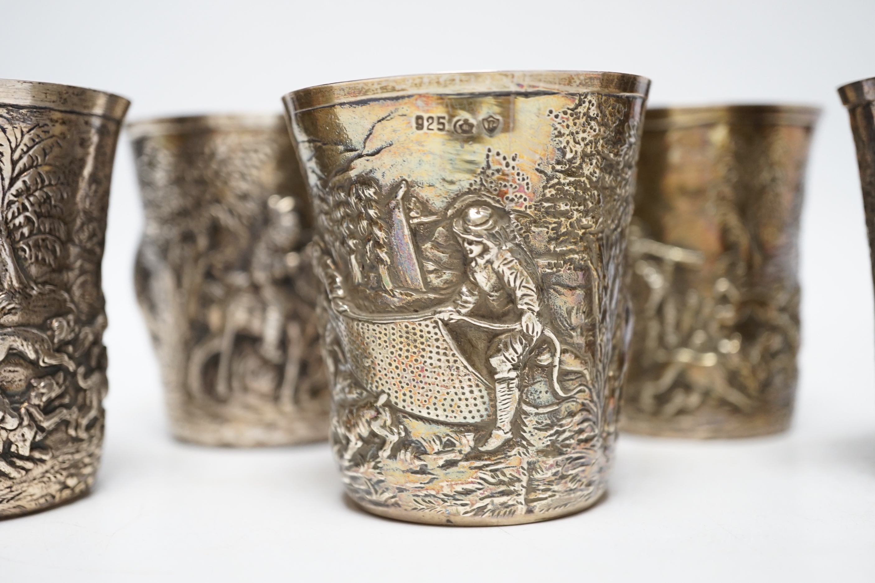 A set of five late 19th century German embossed 925 beakers, decorated with continuous hunting scenes, by Neresheimer Ludwig & Co, 67mm, 16.7oz